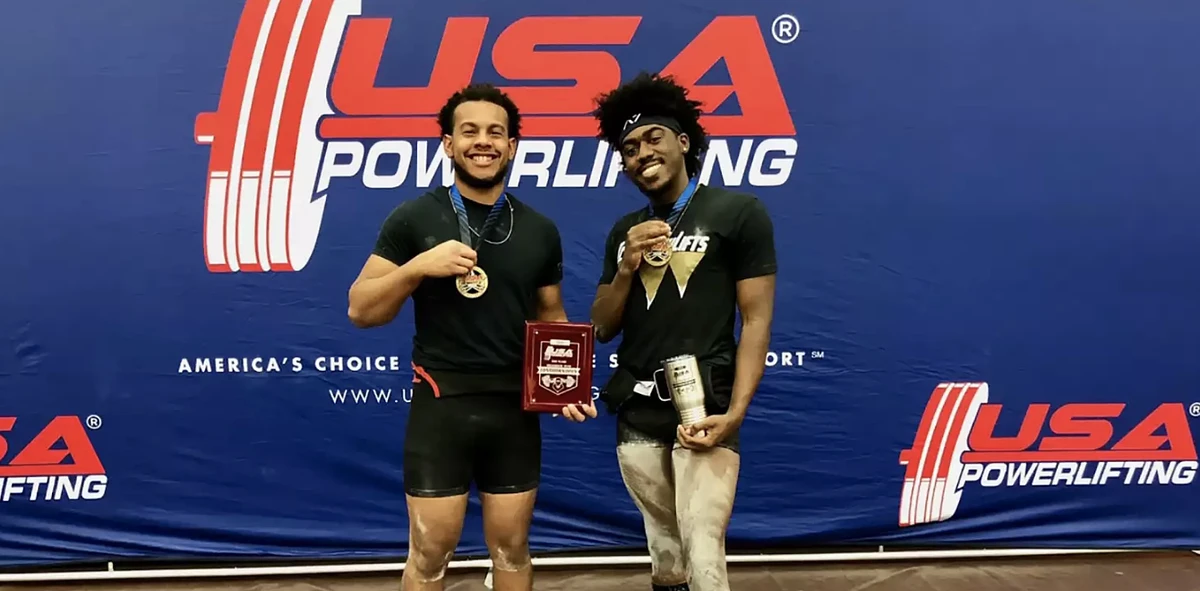 Two male athletes holding medals